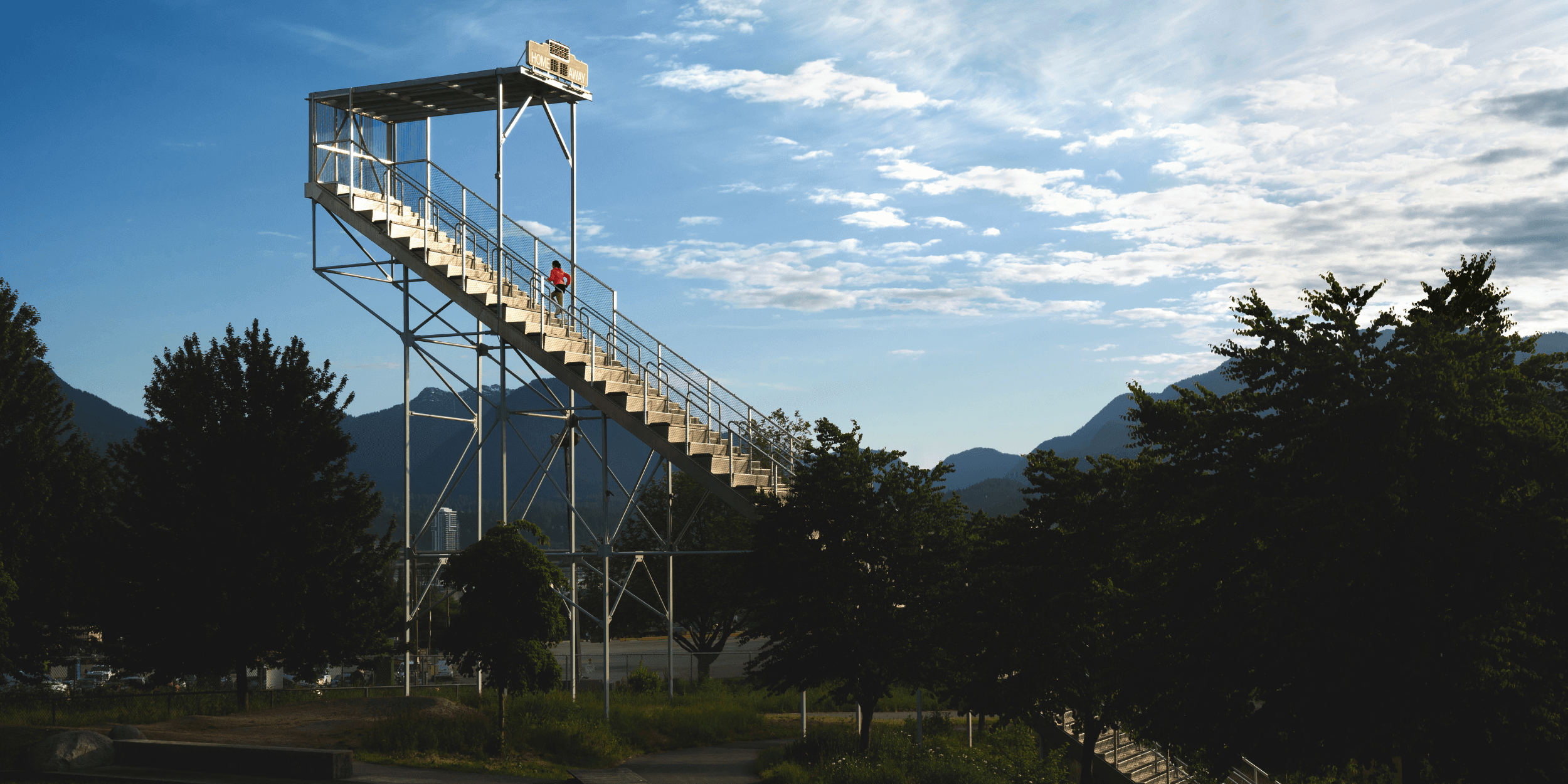 Runner climbing outdoor stairs with mountains in the background